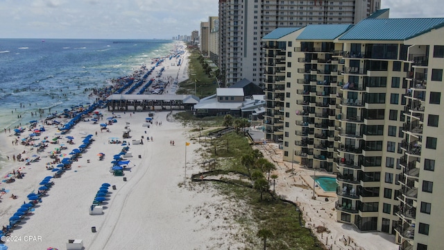 birds eye view of property with a water view and a beach view