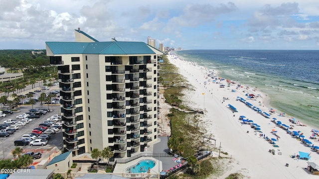 view of property with a view of the beach, a community pool, and a water view