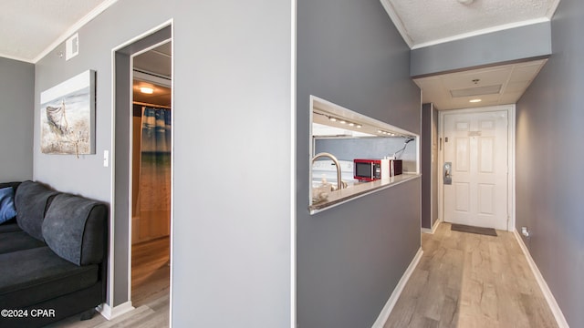 corridor with crown molding and light hardwood / wood-style flooring