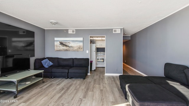 living room featuring ornamental molding and light wood-type flooring