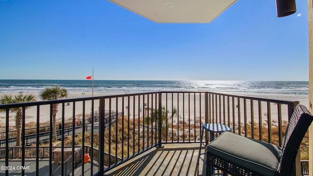 balcony featuring a water view and a beach view