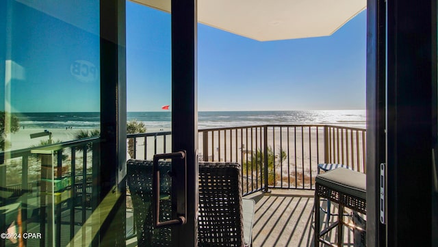 balcony featuring a water view and a view of the beach