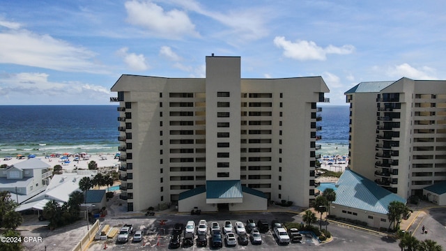 view of building exterior with a water view and a beach view