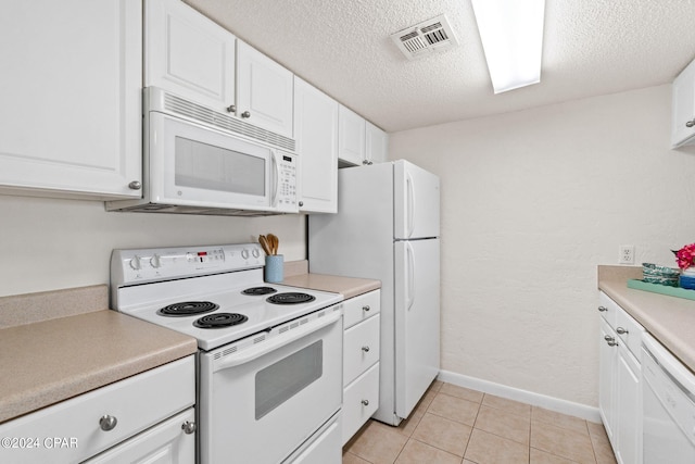 kitchen featuring white cabinets, white appliances, and a textured ceiling