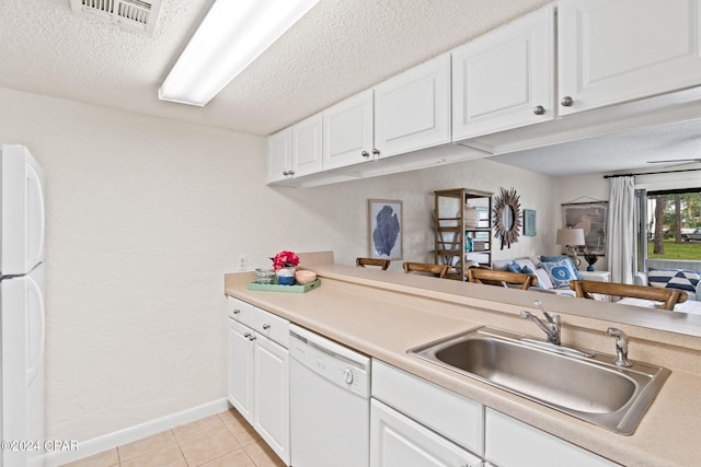 kitchen with white cabinetry, light tile patterned flooring, white appliances, and sink