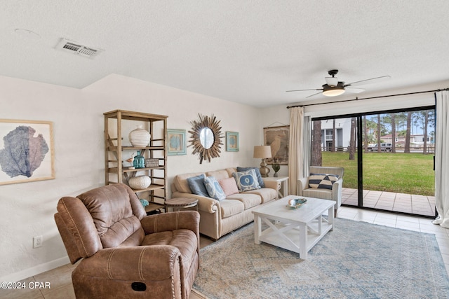 tiled living room featuring ceiling fan and a textured ceiling