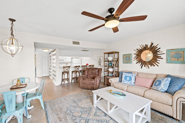 living room featuring ceiling fan with notable chandelier and light tile patterned flooring