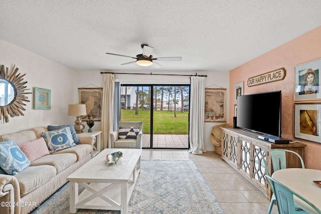 living room with ceiling fan, light tile patterned flooring, and a textured ceiling