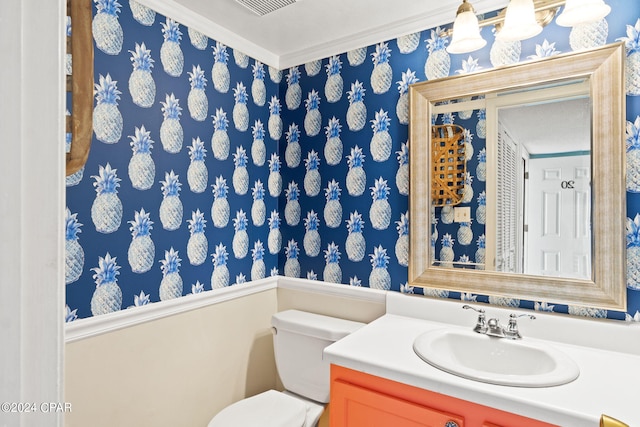 bathroom with vanity, toilet, and ornamental molding