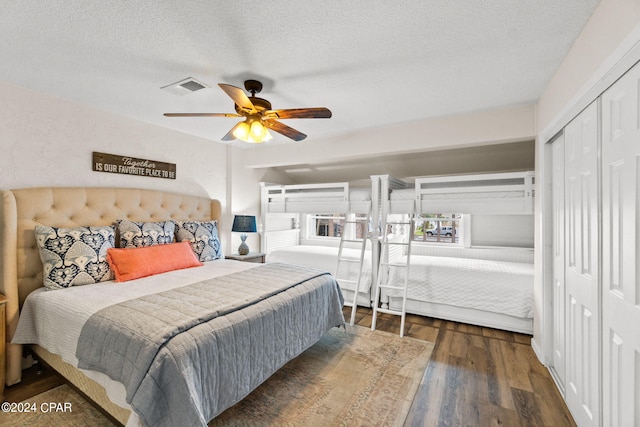 bedroom featuring dark hardwood / wood-style floors, ceiling fan, a textured ceiling, and a closet