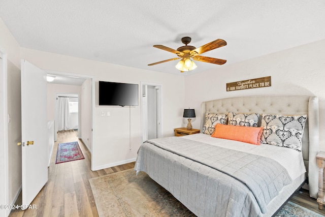 bedroom featuring ceiling fan, a textured ceiling, and hardwood / wood-style flooring