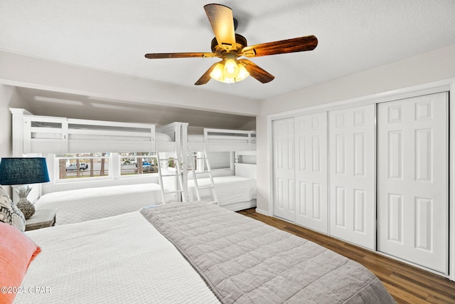 bedroom with a textured ceiling, dark hardwood / wood-style floors, and ceiling fan