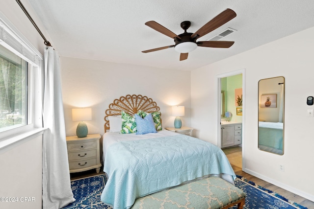 bedroom with wood-type flooring, a textured ceiling, ensuite bath, and ceiling fan