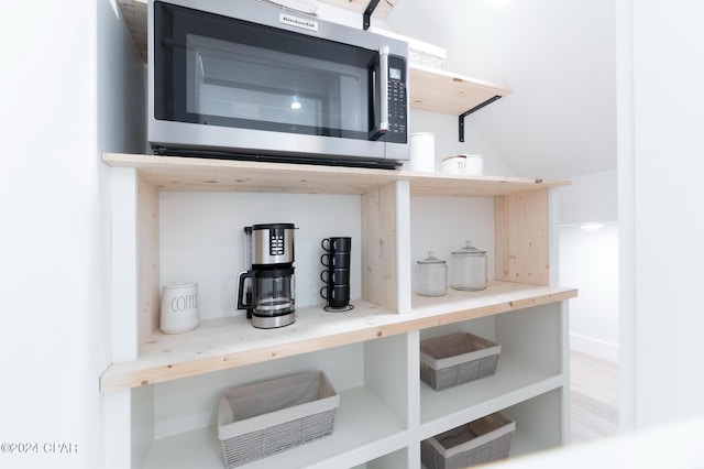 kitchen with premium range hood, white cabinetry, a kitchen island with sink, and stainless steel appliances