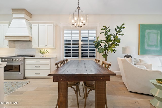 dining room featuring light wood-type flooring and an inviting chandelier