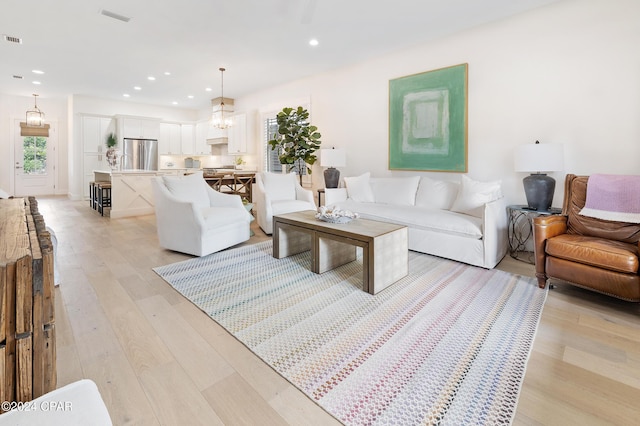 living area featuring light wood-style flooring, visible vents, and recessed lighting