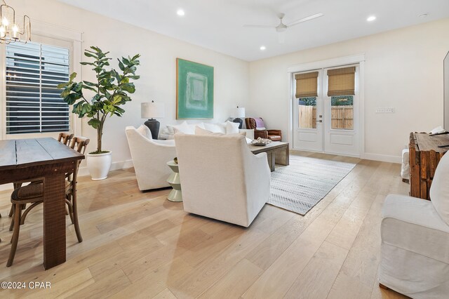 living room with light wood-type flooring and a chandelier