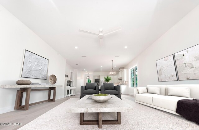 living room featuring light wood-type flooring and a chandelier