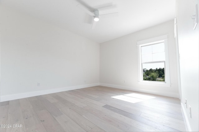 empty room with ceiling fan, light wood-style flooring, and baseboards