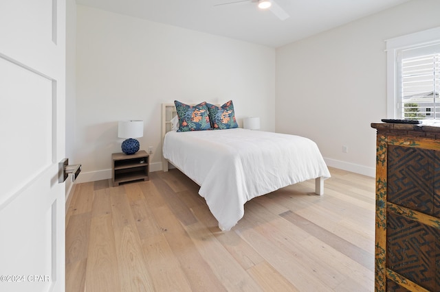 bedroom with a ceiling fan, baseboards, and wood finished floors