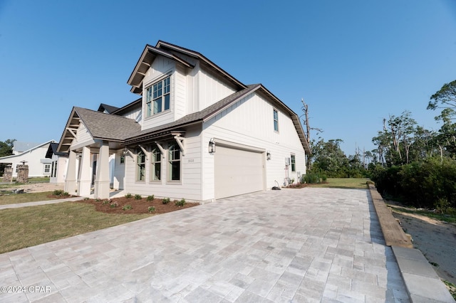 view of front of home with a garage, decorative driveway, and roof with shingles