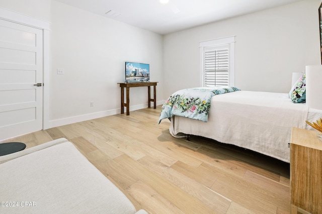 bedroom featuring wood finished floors and baseboards