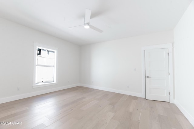 unfurnished room with baseboards, a ceiling fan, and light wood-style floors