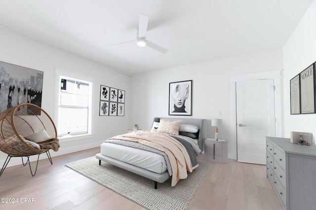 bedroom with light wood-style flooring, baseboards, and ceiling fan