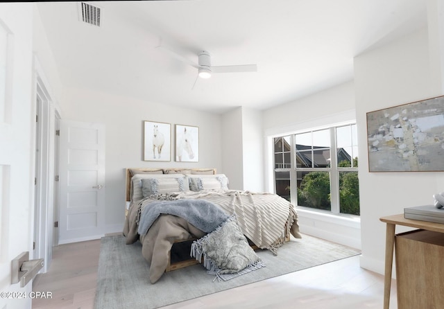 bedroom with light wood-type flooring, baseboards, visible vents, and ceiling fan