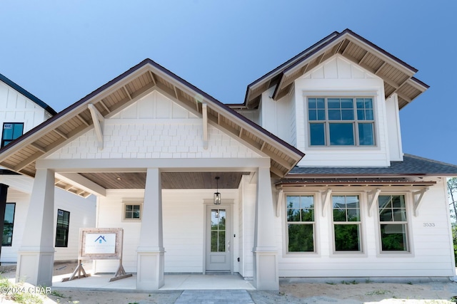 view of front of house with covered porch, a shingled roof, and board and batten siding