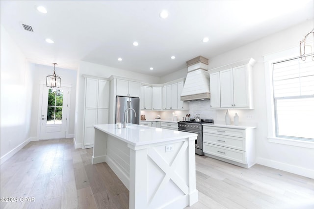 kitchen with stainless steel appliances, white cabinetry, hanging light fixtures, light countertops, and custom exhaust hood