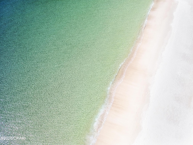 aerial view with a water view and a beach view