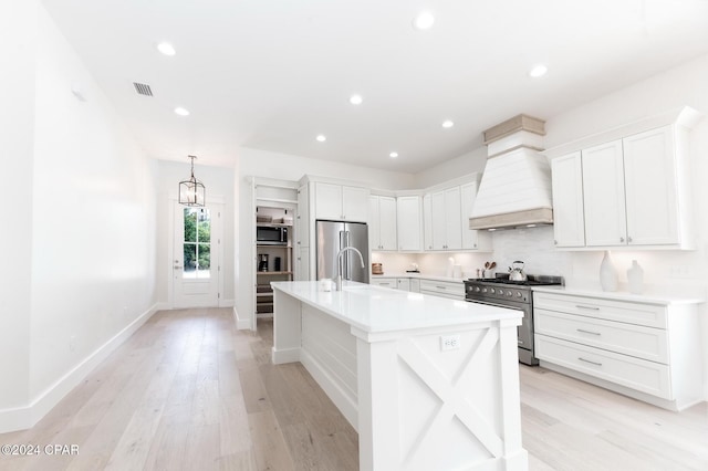 kitchen featuring appliances with stainless steel finishes, light countertops, custom exhaust hood, and white cabinetry