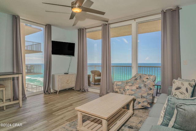 living room featuring expansive windows, light hardwood / wood-style flooring, and ceiling fan