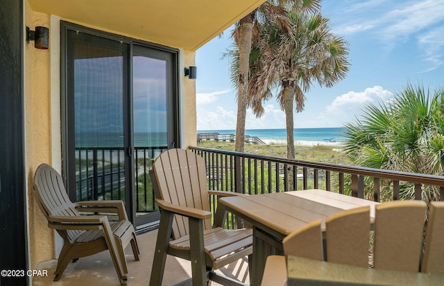 balcony featuring a water view and a beach view