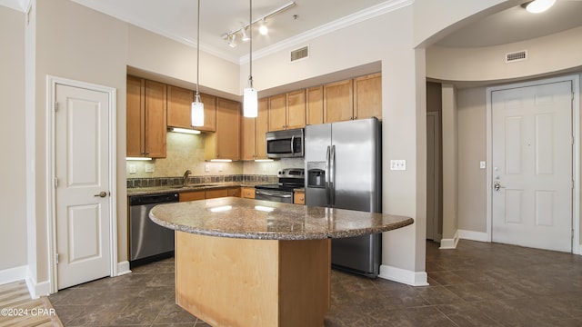 kitchen featuring sink, tasteful backsplash, decorative light fixtures, a kitchen island, and stainless steel appliances