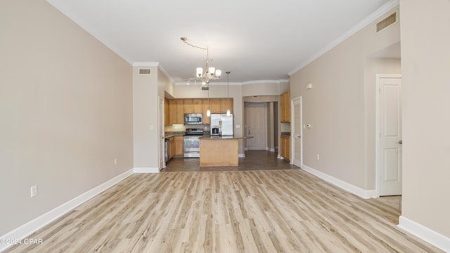 kitchen featuring appliances with stainless steel finishes, crown molding, pendant lighting, a chandelier, and a kitchen island