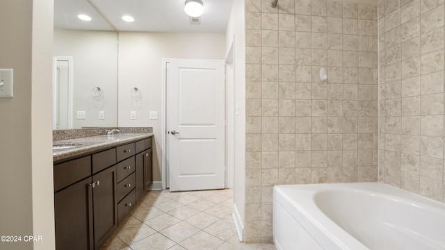 bathroom featuring tile patterned floors, vanity, and a bath