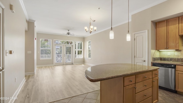 kitchen with french doors, stainless steel dishwasher, ornamental molding, ceiling fan with notable chandelier, and a kitchen island