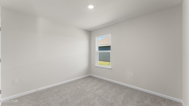 carpeted spare room featuring baseboards