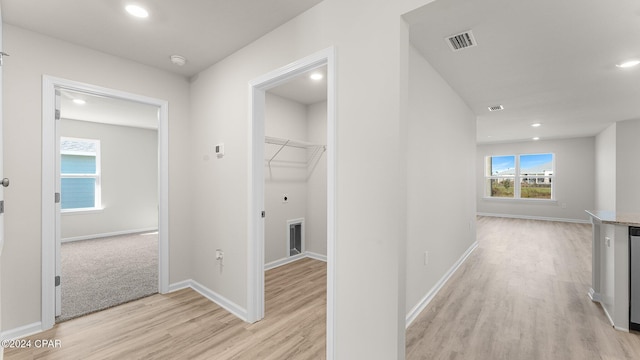 hallway with baseboards, recessed lighting, visible vents, and light wood-style floors