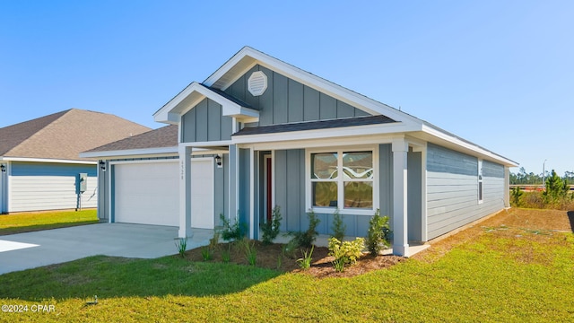 view of front of home with board and batten siding, a front yard, driveway, and an attached garage