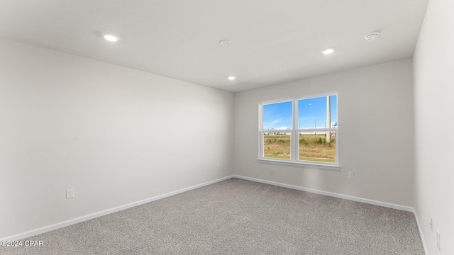 carpeted empty room featuring recessed lighting and baseboards