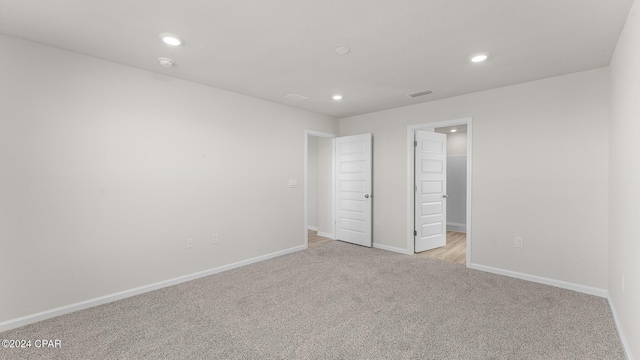 unfurnished bedroom with light carpet, baseboards, and recessed lighting