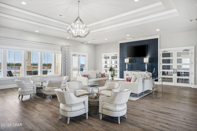 living room with dark wood-style floors, a tray ceiling, and a wealth of natural light