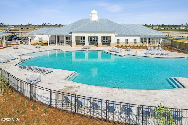 pool with a patio area and fence