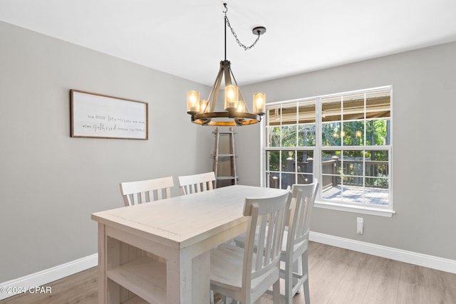 dining space featuring hardwood / wood-style flooring and an inviting chandelier