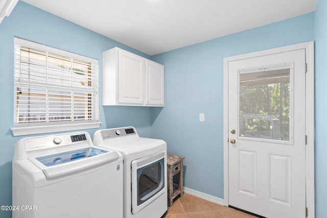 laundry area featuring light tile patterned flooring, cabinets, and separate washer and dryer