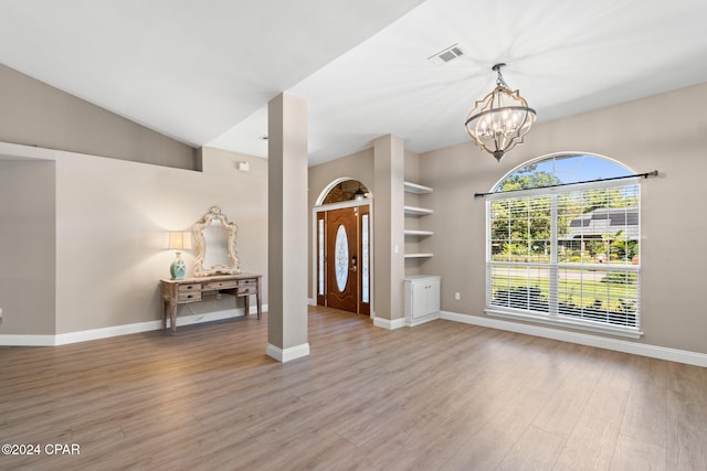 interior space featuring light hardwood / wood-style floors, a notable chandelier, and lofted ceiling