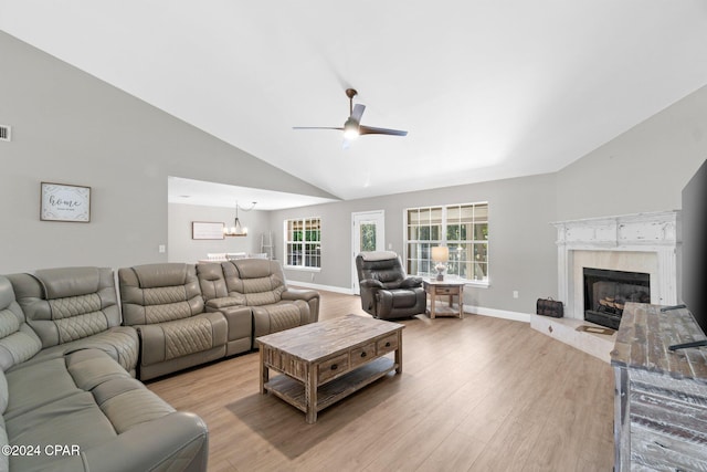 living room with light hardwood / wood-style floors, high vaulted ceiling, and ceiling fan with notable chandelier